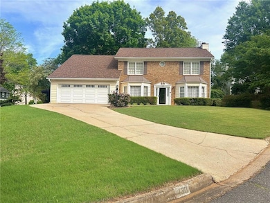 Colonial-style house with driveway, a chimney, a f