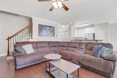 Living area with crown molding, dark wood finished