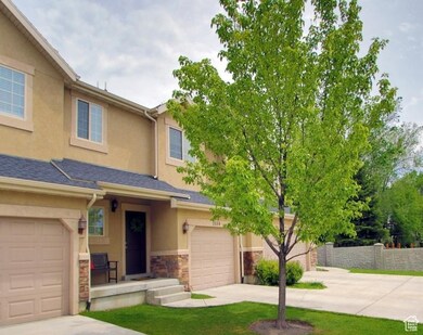 View of front of property with concrete driveway, an attached garage, stucco siding, stone siding, and a shingled roof