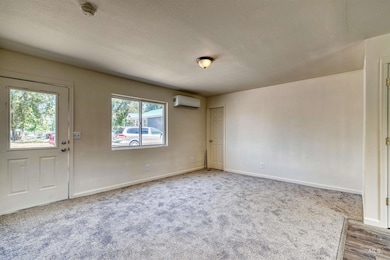 Carpeted entrance foyer featuring a textured ceiling and baseboards