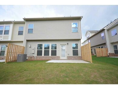 Rear view of property featuring brick siding, a patio area, and cooling unit