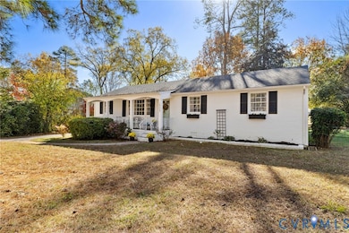 Ranch-style house with a porch, a front yard, and brick siding