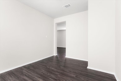 Unfurnished room with baseboards and dark wood-style floors