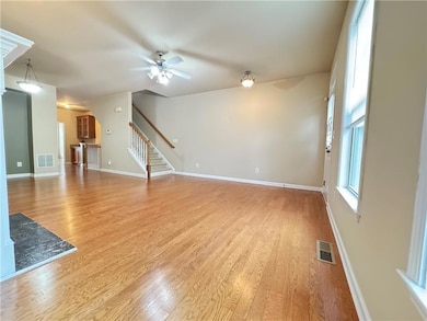 Unfurnished living room with stairs, light wood-ty