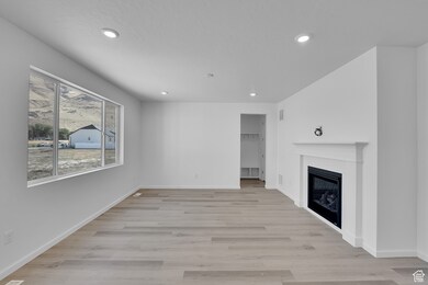 Unfurnished living room featuring light wood-type flooring, a fireplace, and recessed lighting