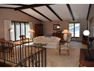Lovely living room features vaults and exposed bea