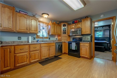 Kitchen featuring appliances with stainless steel finishes, brown cabinets, and healthy amount of natural light