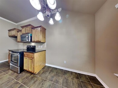 Kitchen with appliances with stainless steel finishes, tasteful backsplash, a chandelier, brown cabinetry, and ornamental molding