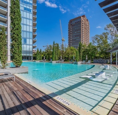 Community pool featuring a deck, a patio area, and a view of city