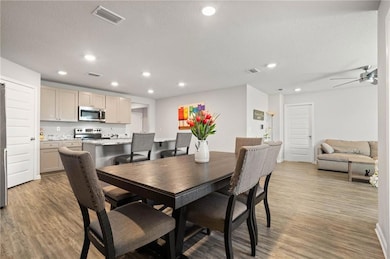 Dining area with light wood-style floors, a textured ceiling, recessed lighting, and a ceiling fan