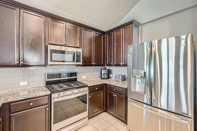 Kitchen featuring dark brown cabinets, stainless 