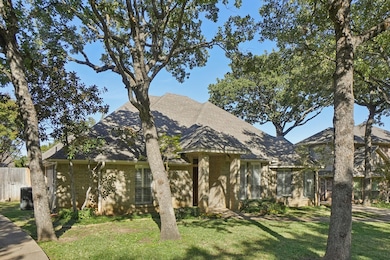 View of front facade featuring a shingled roof and brick siding
