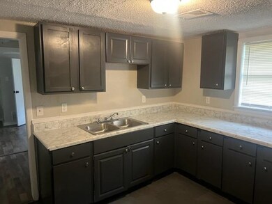 Kitchen featuring a textured ceiling and sink
