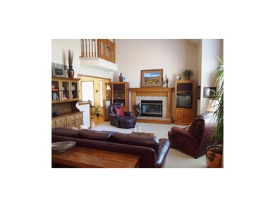 Living room with vaulted ceiling and fireplace.