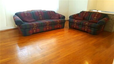 The sunlit livingroom features hardwood floors.