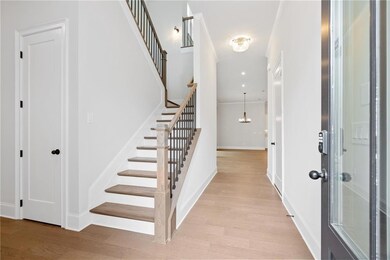 Stairs with an inviting chandelier, crown molding,