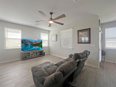 Living room with ceiling fan, wood finished floor