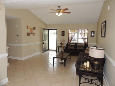 Spacious Living Room features a Cathedral ceiling, tile flooring, and  chair rail!