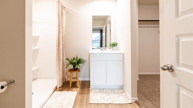 Bathroom with vanity, a stall shower, and light wood-style floors