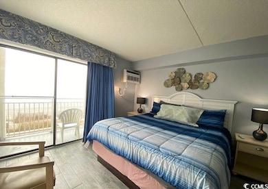 Bedroom with a textured ceiling, access to outside