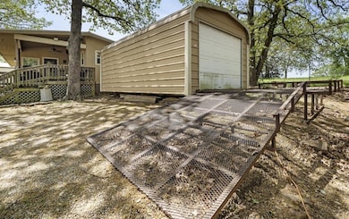 Wooden deck with a garage, ceiling fan, and an outdoor structure