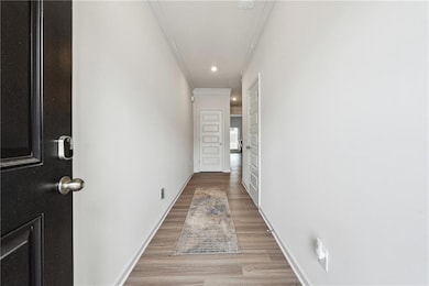 Hall featuring crown molding and light wood-type f