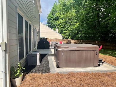 View of patio with a hot tub and a fenced backyard
