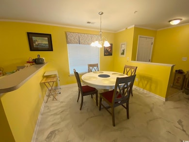 Dining space featuring ornamental molding and an i