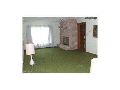 Large living room has brick fireplace that also op