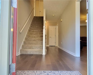 Stairs featuring baseboards, a textured ceiling, a