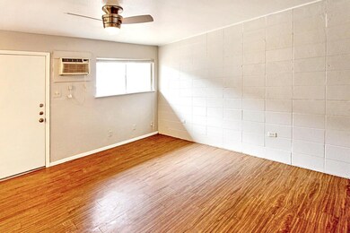 Spare room with an AC wall unit, a ceiling fan, b