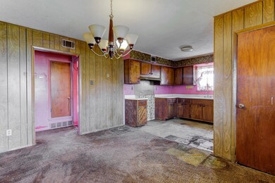 Kitchen with light countertops, light carpet, wood