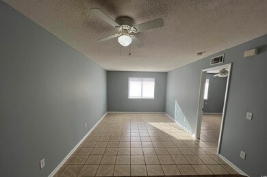 Empty room with light tile patterned floors, a tex