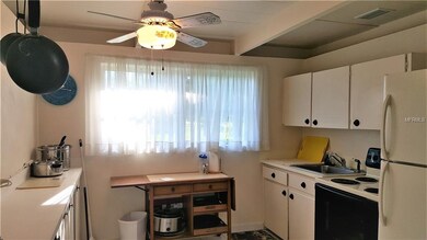 Kitchen  has a ceiling fan & tiled flooring.