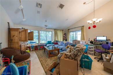The living area has a vaulted ceiling a huge window to let in natural light.