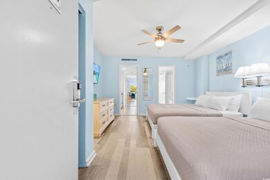 Bedroom with ceiling fan and light hardwood / wood