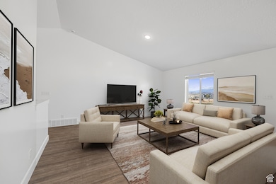 Living area featuring wood finished floors, recessed lighting, and high vaulted ceiling