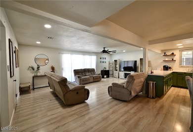 Living area featuring recessed lighting, light wood-type flooring, a ceiling fan, and a textured ceiling