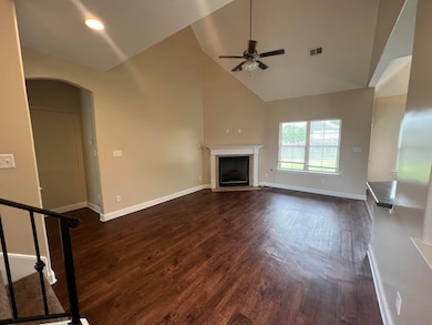 Unfurnished living room with ceiling fan, high vau