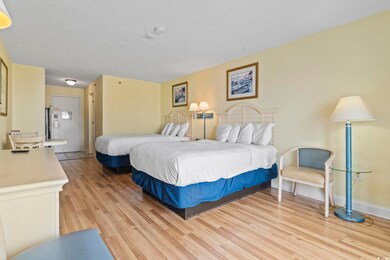 Bedroom with light wood-style flooring, baseboards, and ensuite bathroom