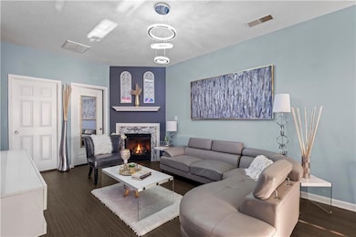 Living area with a textured ceiling, a fireplace, 