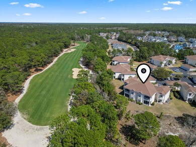 Aerial view with view of golf course, a wooded view, and a residential view