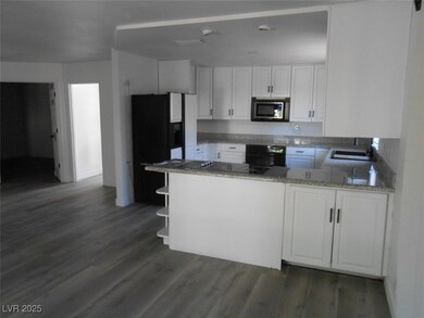 Kitchen with black refrigerator with ice dispenser