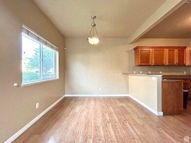 Unfurnished dining area featuring light wood finished floors and beam ceiling