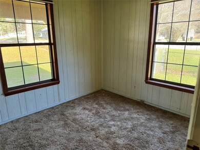 Carpeted spare room featuring wood walls