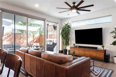 Living area featuring a ceiling fan, wood finishe