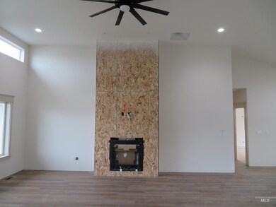 Unfurnished living room with wood finished floors, a towering ceiling, ceiling fan, recessed lighting, and a fireplace