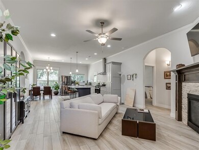 Living room with crown molding, a fireplace, light