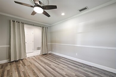 Empty room with wood-type flooring, crown molding,