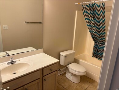 Full bathroom featuring tile patterned floors, vanity, and shower / bath combo with shower curtain